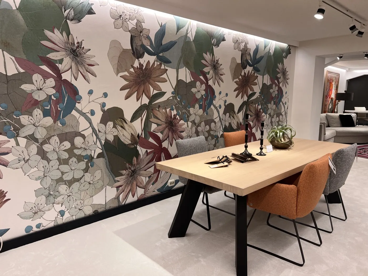 Eethoek bij een bloemenwand met verlichting in de showroom van Heida Interieurs